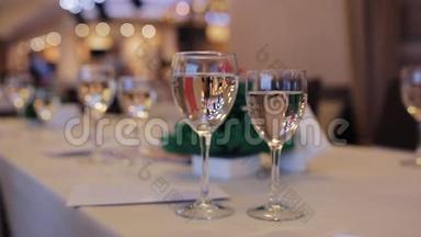 桌上有香槟酒杯。 服务员把香槟倒进玻璃杯里。 企业活动
